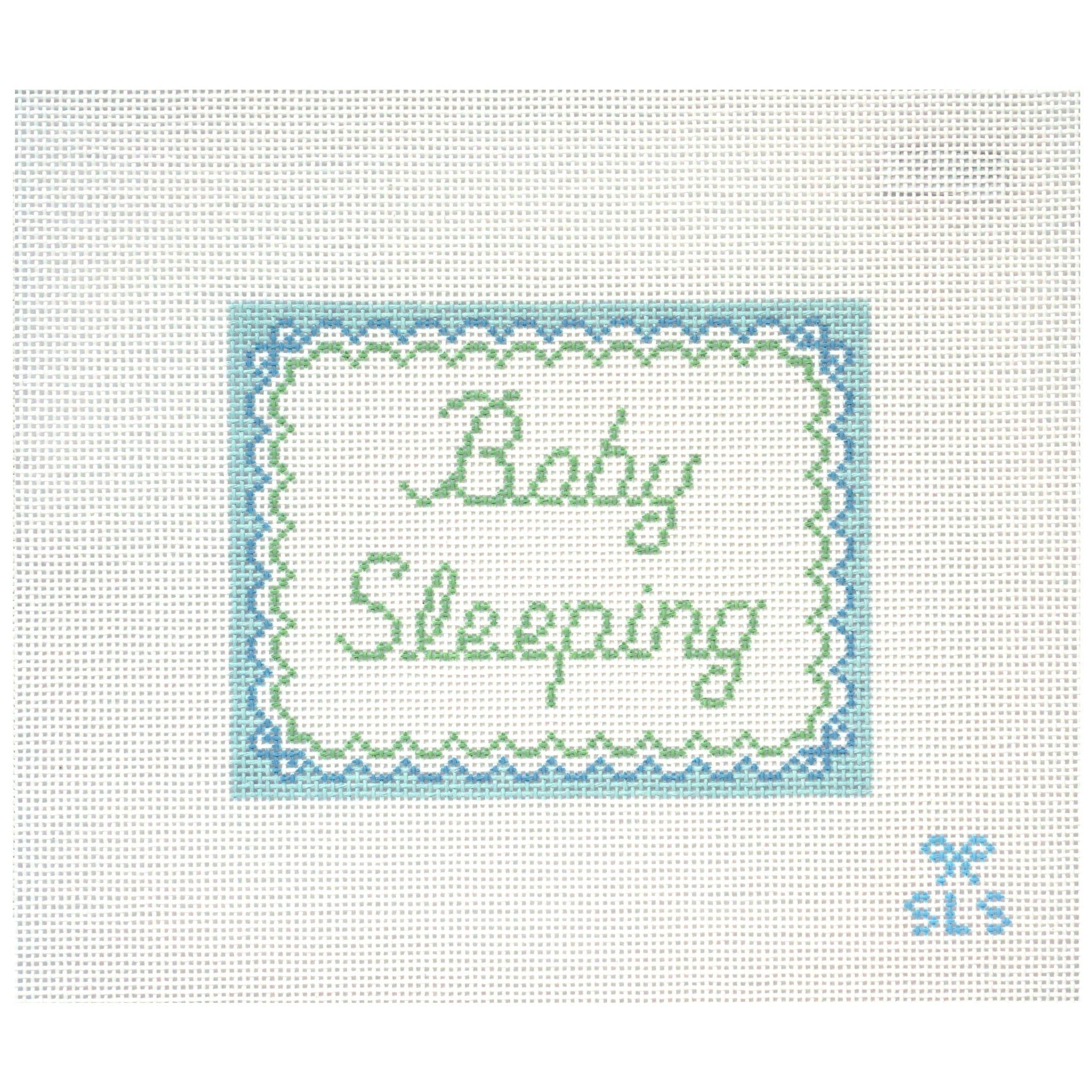 Needlepoint canvas with 'Baby Sleeping' text on a white background with scalloped edges