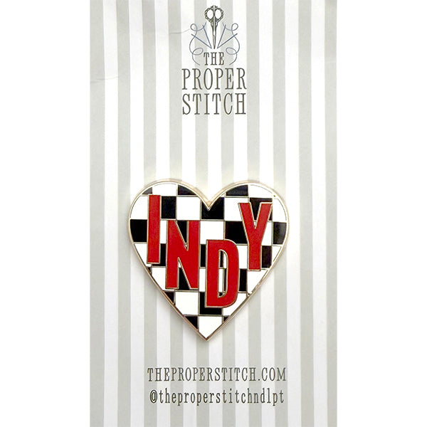 A needle minder design of a black and white checkered heart with the word "INDY" in the center to represent Indianapolis.