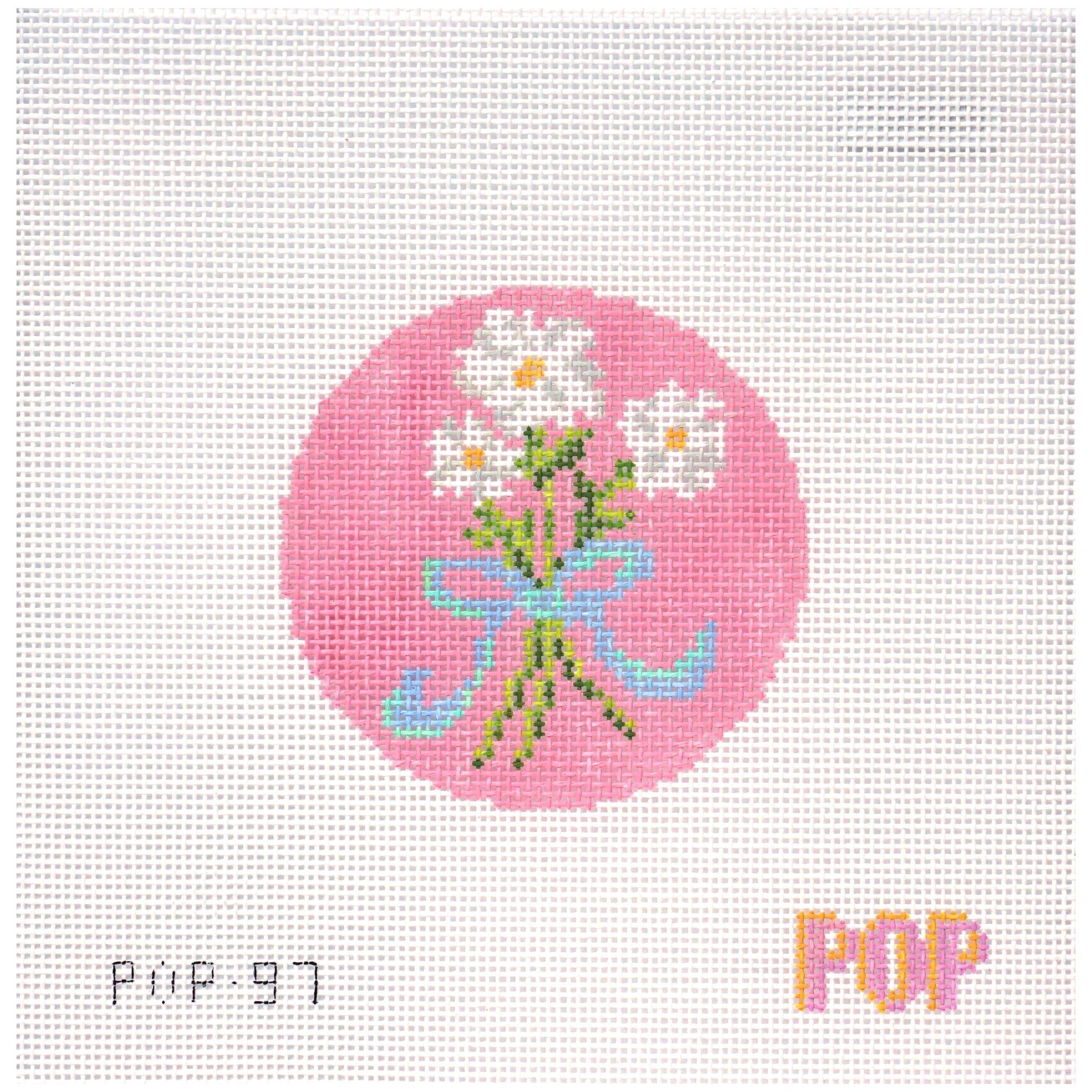 Needlepoint canvas of flowers and a bow on a pink circle
