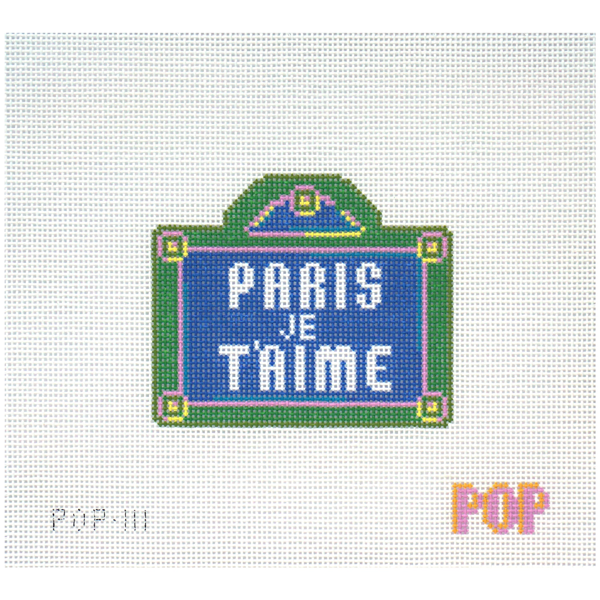 Needlepoint canvas of a sign with 'PARIS JE T'AIME' text on a white background.