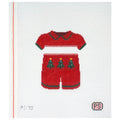 Needlepoint canvas of a red outfit with Christmas tree designs on a white background